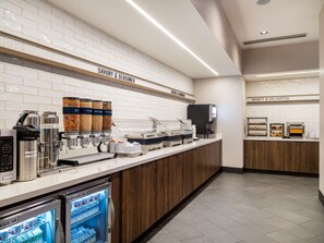 A breakfast bar with a coffee machine, a beverage cooler, and containers of whole milk, soy milk, and almond milk. - Tru By Hilton Atlanta Airport College Park (College Park)