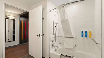 A modern bathroom with a walk-in shower, a bathtub, and a toilet. There are toiletries on the wall and a towel rack.