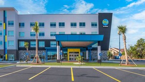 A modern hotel with a blue and white facade, a covered entrance, and palm trees in front. - Tru By Hilton Santee (Santee)