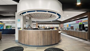 A modern hotel lobby with a central reception desk, a children's play area, and a restaurant named "Top It Break." - Tru By Hilton Santee (Santee)