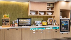 Una cocina moderna con armarios de madera, cafetera integrada y refrigerador.