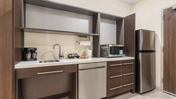 A modern kitchen with a stainless steel refrigerator, a microwave, and a dishwasher.