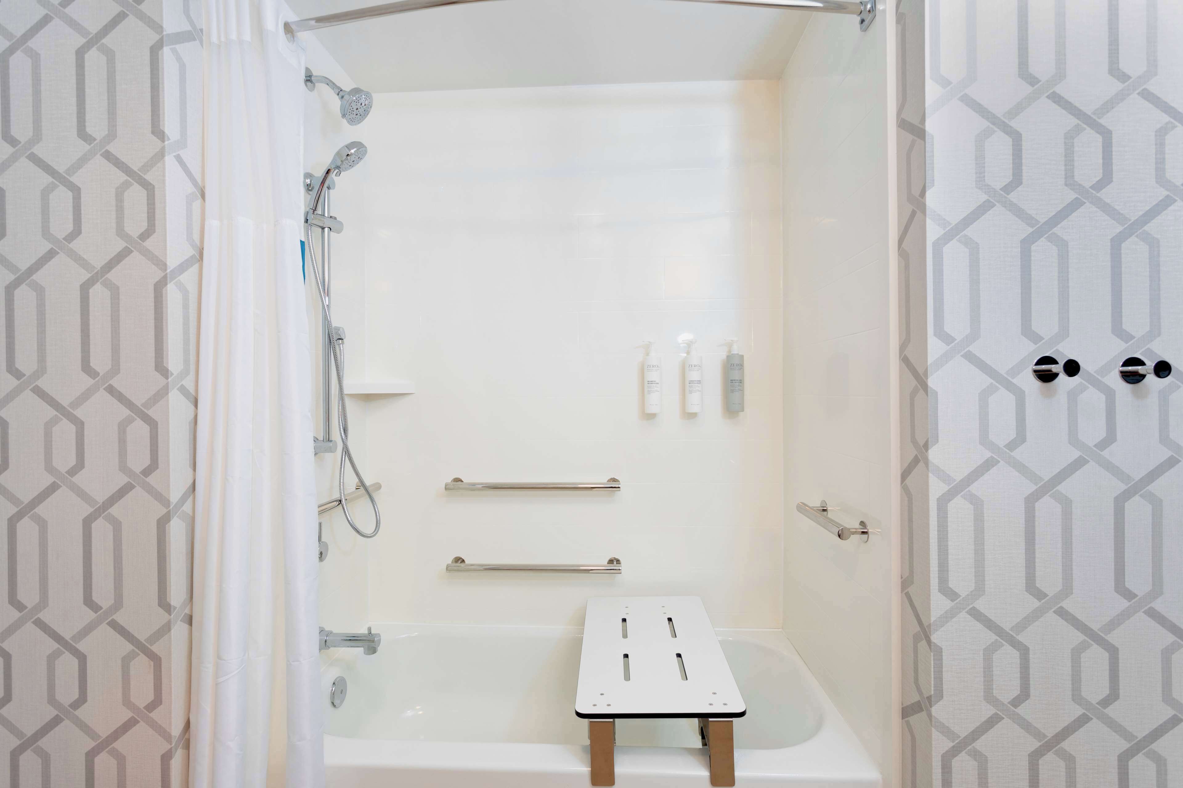 Un bagno moderno con doccia, vasca e un piccolo tavolino da trucco.