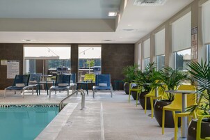 A pool area with lounge chairs and potted plants.