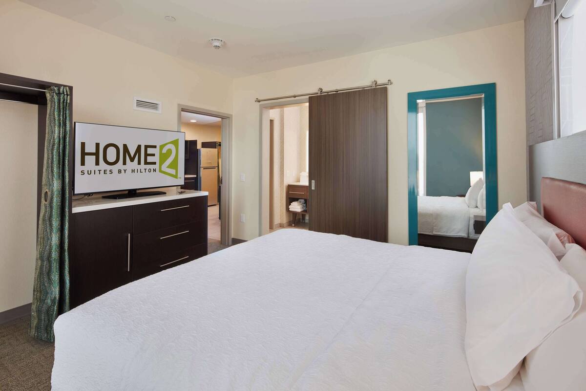 Een hotelkamer met een bed, een televisie, een kledingkast en een badkamer.