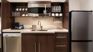 A modern kitchen with a built-in microwave, stainless steel appliances, and wooden cabinets.