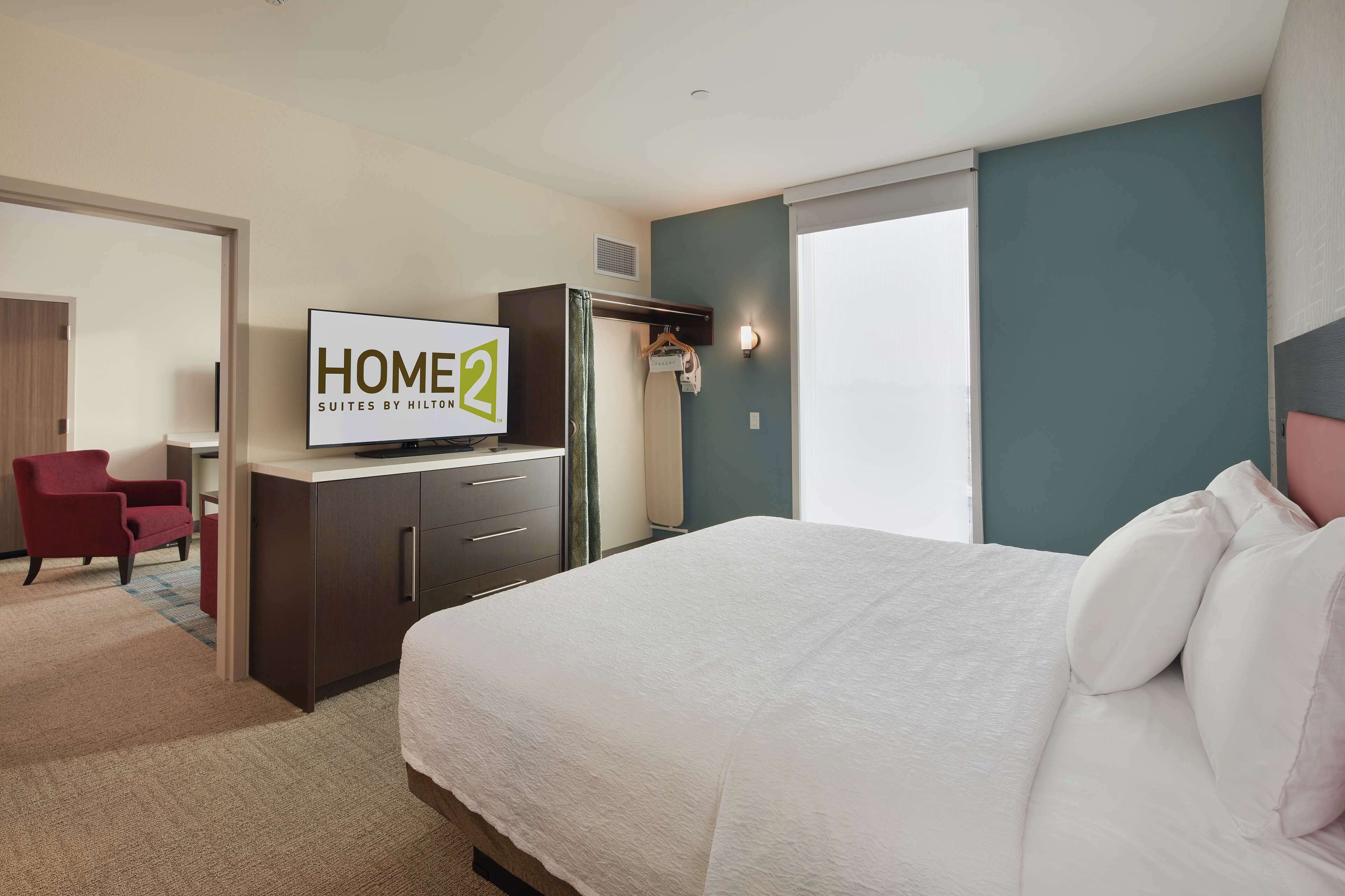 Een hotelkamer met een bed, een televisie, een bureau en een stoel.