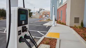 Una estación de carga para vehículos eléctricos con pantalla digital, un código QR y un puerto etiquetado como 'Port 1'.