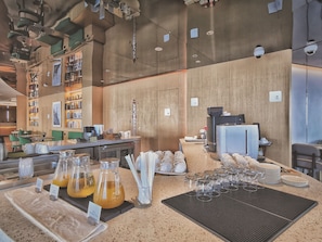 A modern cafe with a bar area, bookshelves, and a coffee machine.