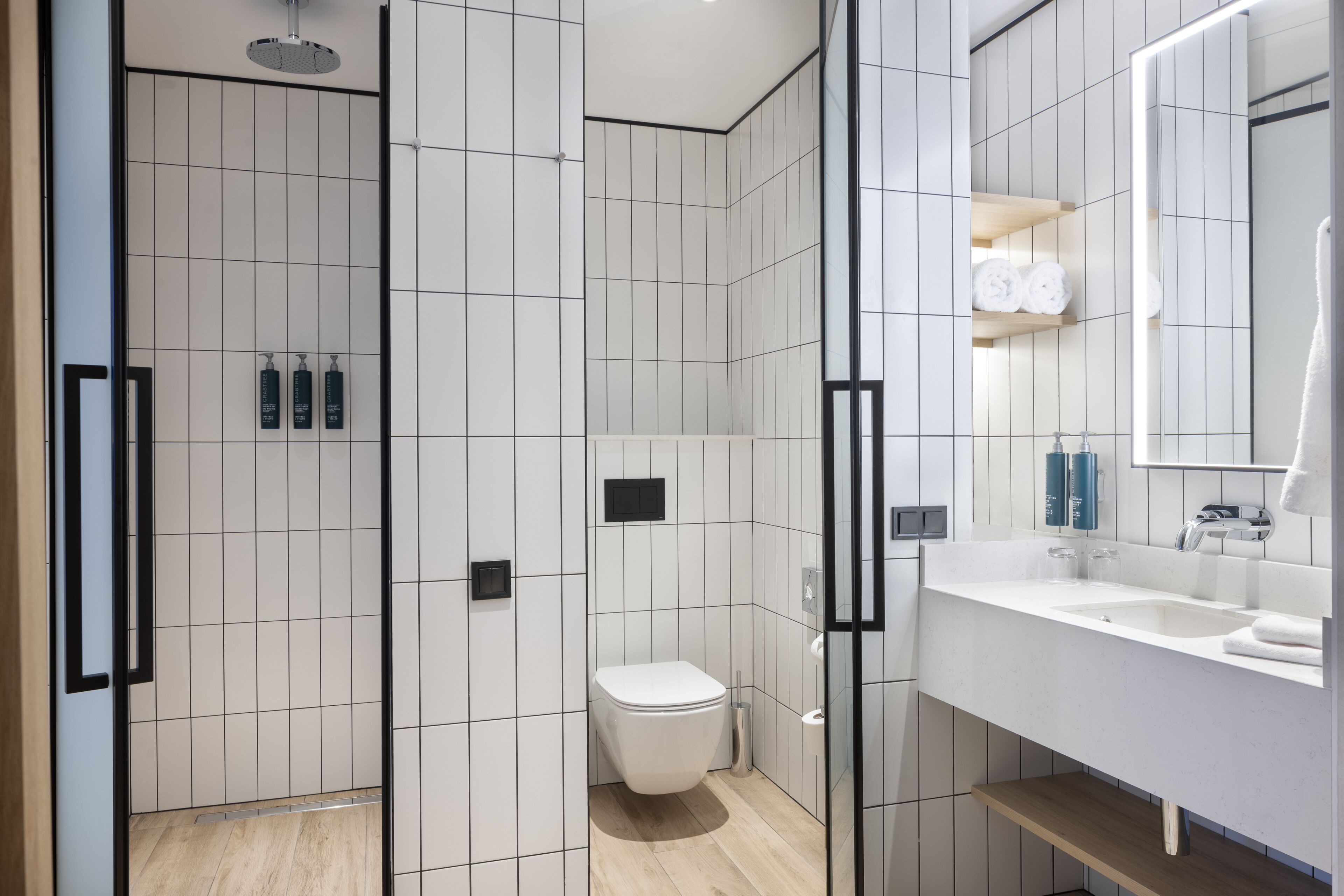 Une salle de bain moderne équipée d’une douche, de toilettes et d’un lavabo.