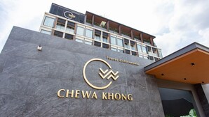 Ein Gebäude mit modernem Design, das ein auffälliges Schild mit der Aufschrift "CHEWA KHONG" zeigt.