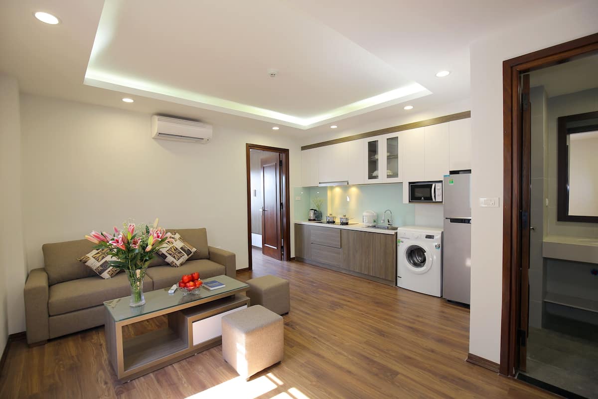 A modern apartment with a living room, kitchenette, and a dining area.