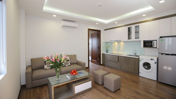 Un apartamento moderno con sala de estar, kitchenette y lavadora.