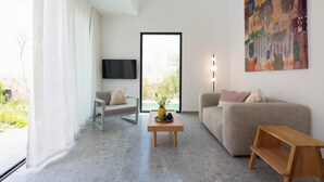 Un salon moderne avec un canapé, une table basse et un tableau au mur.
