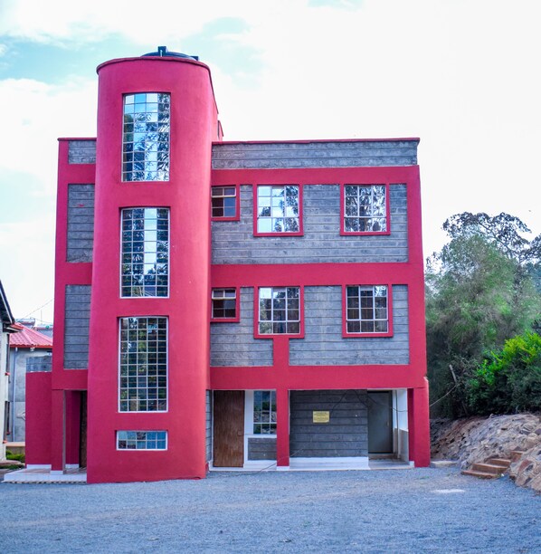 A modern two-story building with a unique cylindrical section, large windows, and a garage.