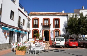 Experience the charm of a traditional European-style building, featuring a central entrance and adjacent café-bar.