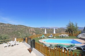 Relax by the serene pool surrounded by lush hills and comfortable lounge chairs.