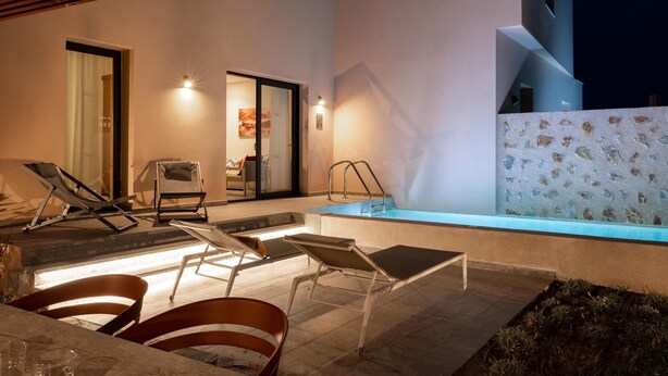 Área de piscina externa com espreguiçadeiras, uma piscina pequena e um espaço coberto para relaxamento.