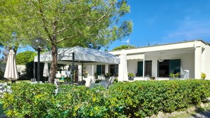 A modern building with a covered outdoor seating area, a swimming pool, and well-maintained landscaping. - Hibiscus Beach Village - Family apartments within walking distance of the sea (Follonica)