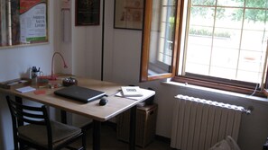 A small office space with a desk, chair, laptop, and a radiator.