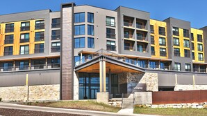 A multi-story building with a modern architectural design, featuring balconies and large windows.