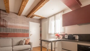A modern kitchen with a built-in oven, a dining table, and a bar stool.