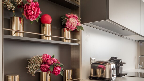 A modern kitchen with metallic shelves holding decorative flowers and a toaster. - Ruga Bella Gold Apartment R&R (Venecia)
