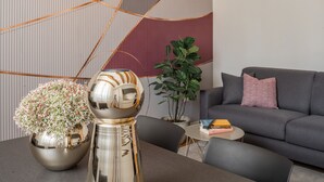 A modern living room with a grey sofa, a small round table, and decorative vases. - Ruga Bella Gold Apartment R&R (Venecia)