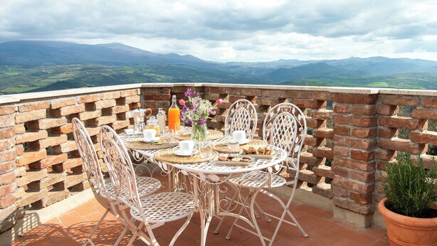 A terrace with a table set for breakfast, overlooking a mountainous landscape. - Il Borghetto - The House of Elba, rooftop panoramic terrace (Castelnuovo dell'Abate)