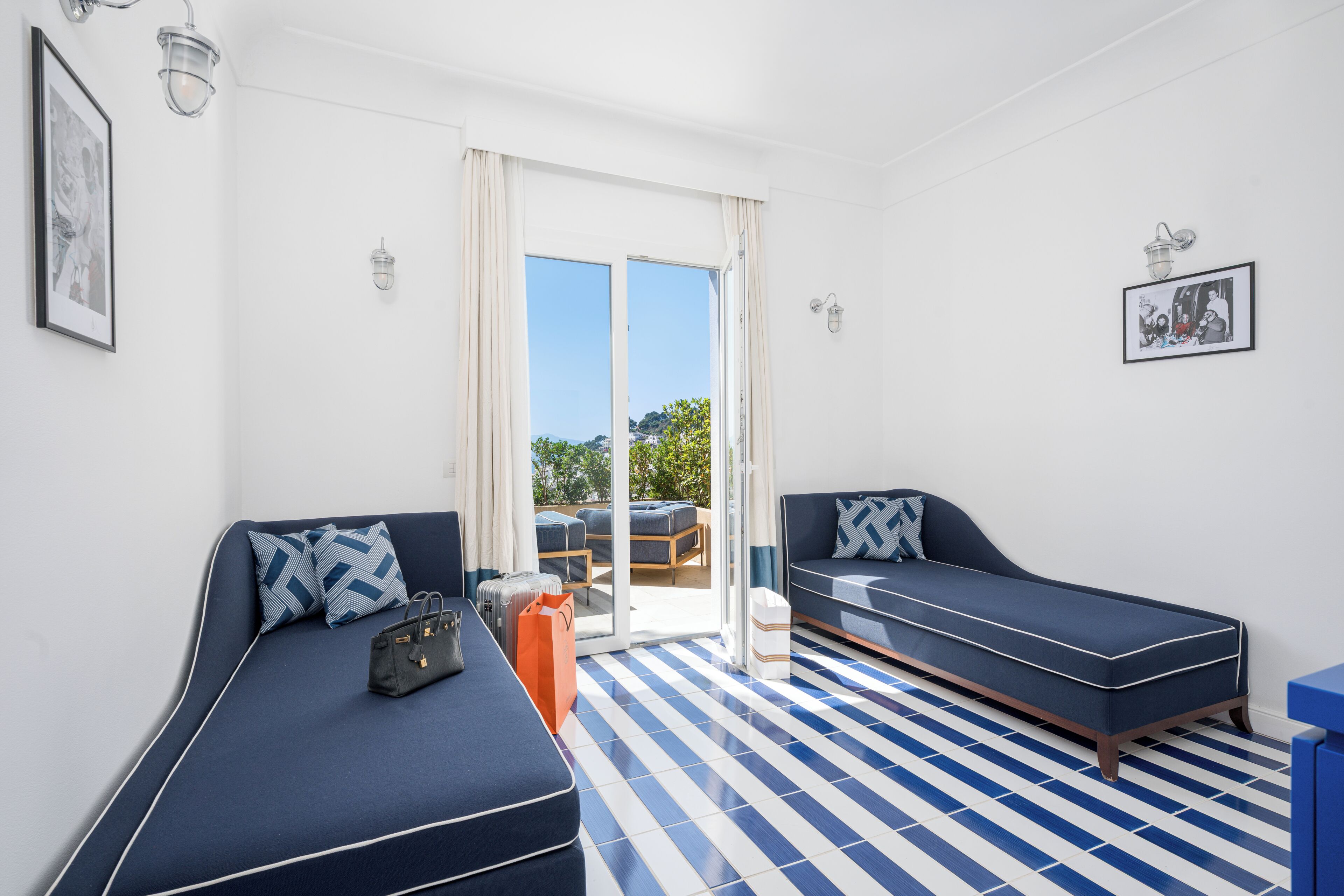 Una habitación con dos sofás, un suelo estampado y vistas a través de un ventanal.