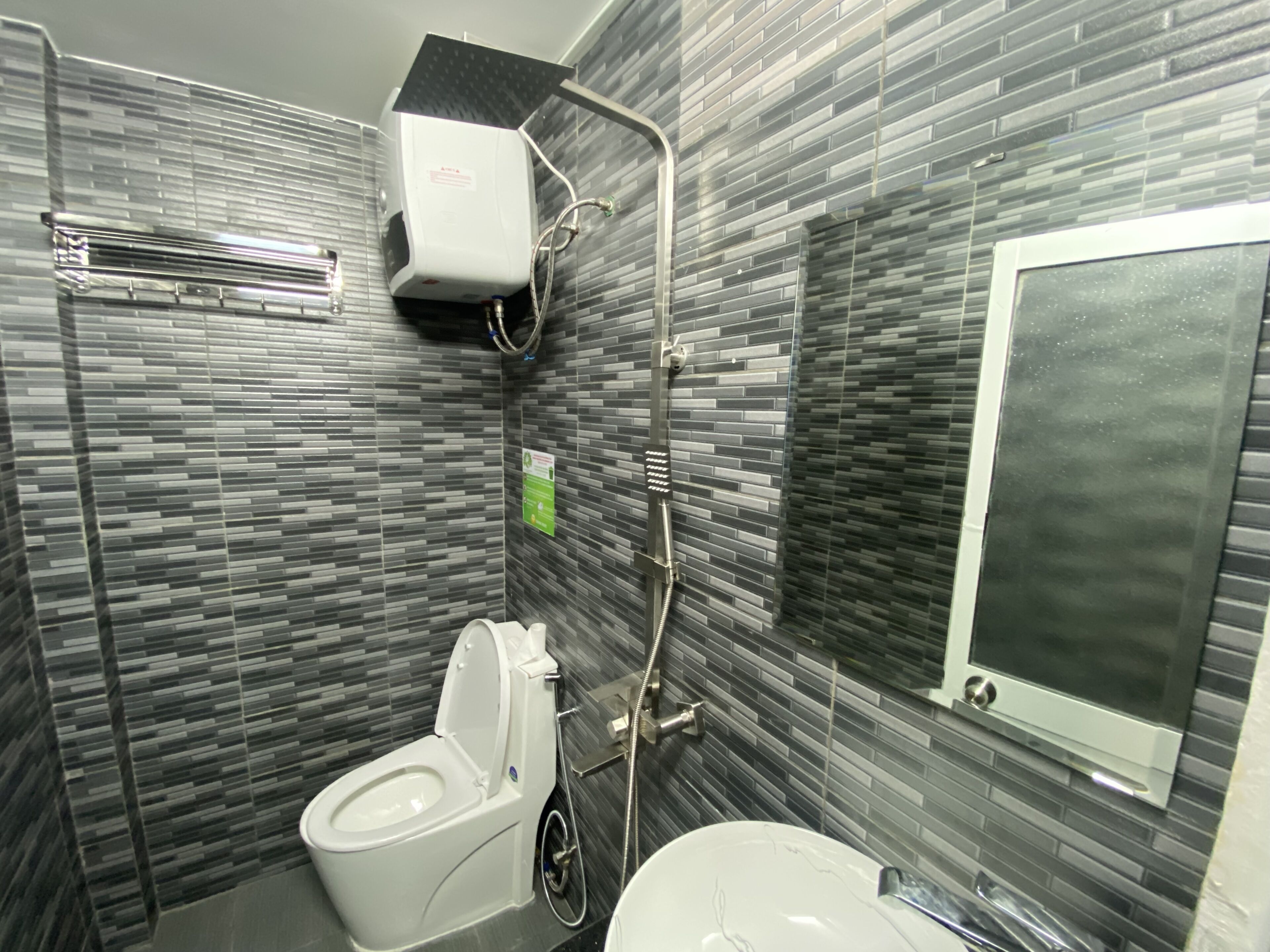 A bathroom with a toilet, bidet, and a sink.