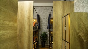 A narrow hallway with wooden walls, a potted plant, and shelves with books and decorative items. - S Phuot Da Nang Hostel (Da Nang)