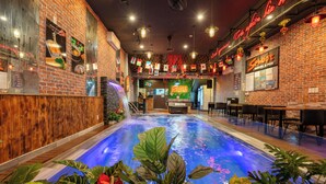 A restaurant with a pool, brick walls, and various flags. - S Phuot Da Nang Hostel (Da Nang)