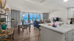 Une chambre d’hôtel moderne dotée d’un balcon, d’un coin repas et d’une cuisine.
