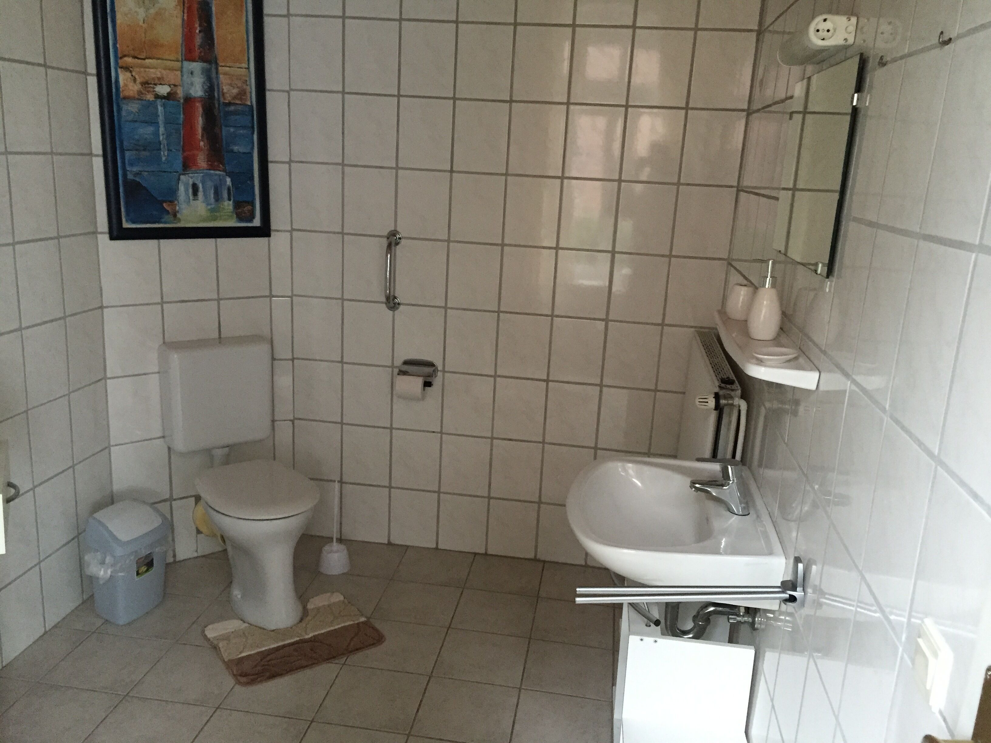 Ett badrum med toalett, bidé, handfat och en spegel.