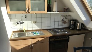 Eine Küche mit Spüle, Herd und Kaffeemaschine.