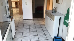 A kitchen with white cabinets, a refrigerator, and a broom.