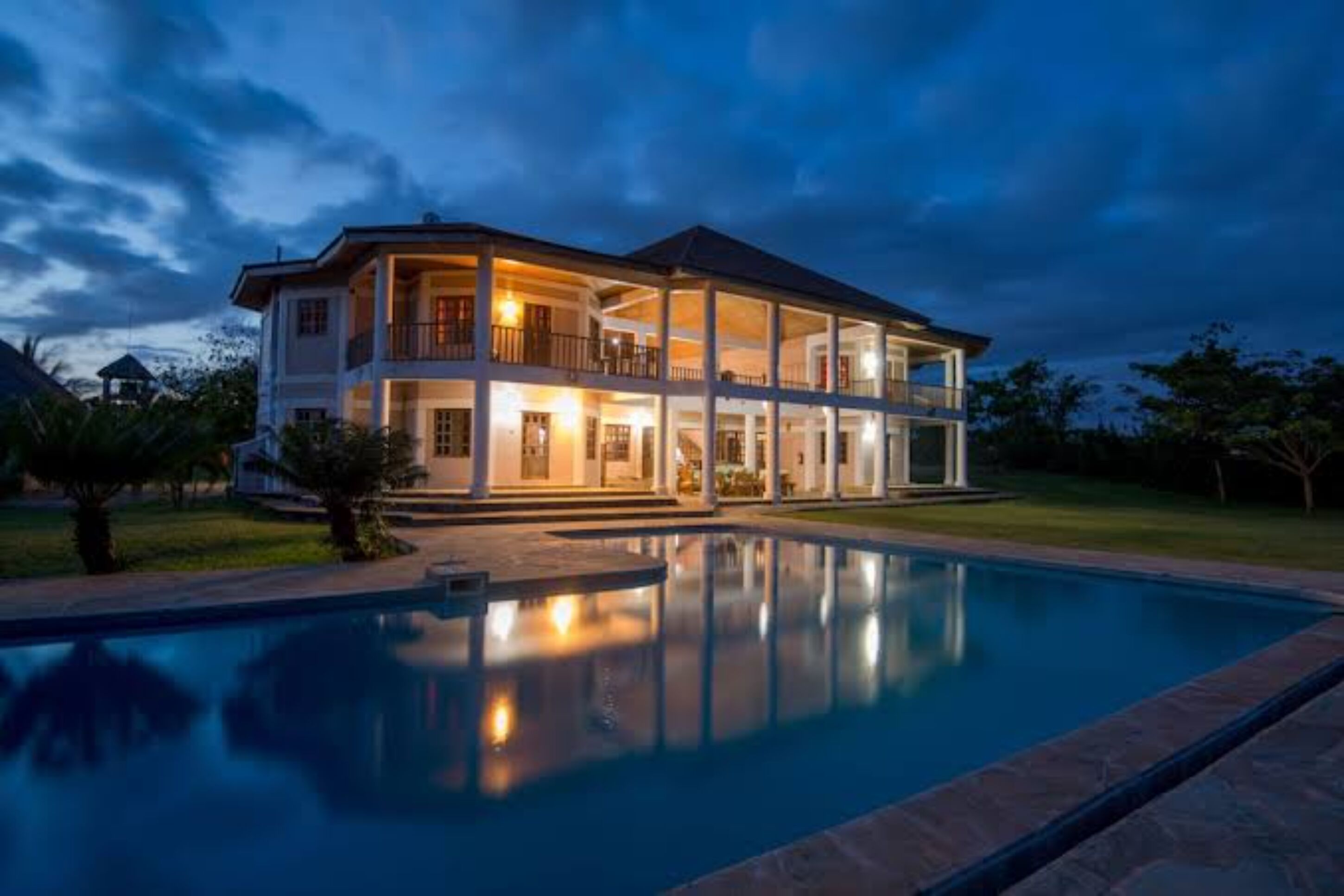 Une maison à deux étages avec une piscine à l’avant.