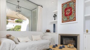 Una sala de estar moderna con un sofá, una mesa redonda de centro y una chimenea.