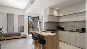 Uma cozinha moderna com uma ilha de madeira, cadeiras pretas e uma mesa de jantar.