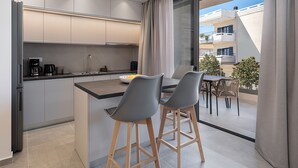 Cozinha moderna com ilha central, banquetas e vista para a varanda.