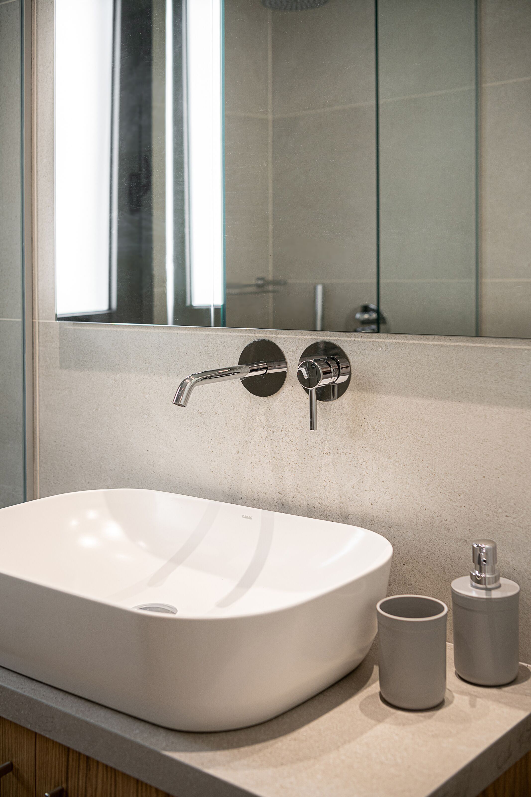 A bathroom with a white sink, a mirror, and a glass shower enclosure.