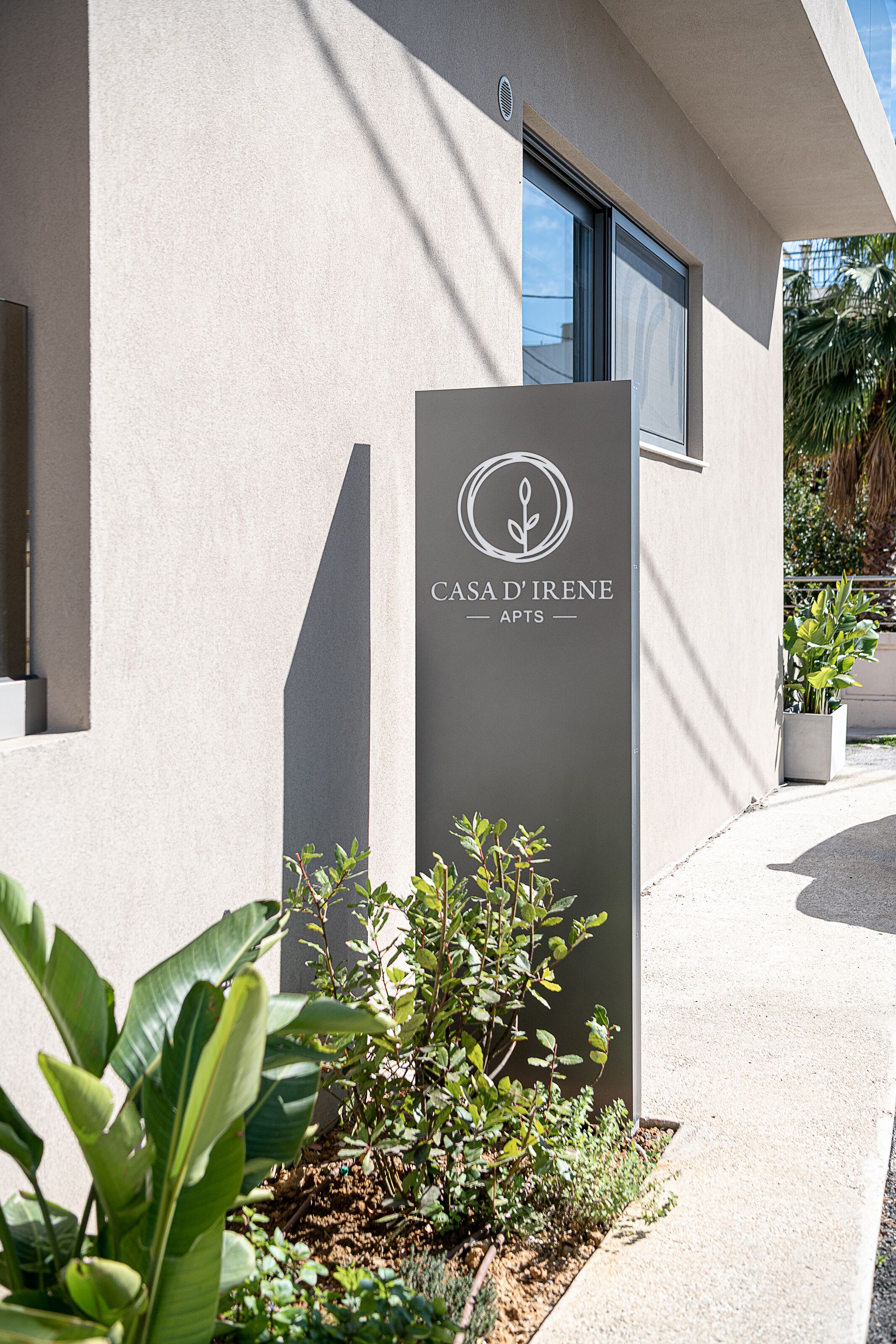 Um edifício moderno com uma placa que diz 'CASA D'IRENE APTS'.