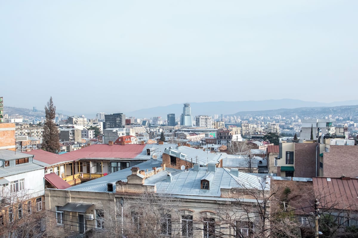 A cityscape with various buildings, including a prominent skyscraper in the distance.