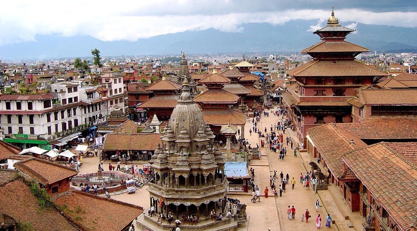 A historic cityscape with traditional architecture, including a prominent temple with a tiered roof and a large central dome.