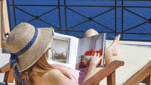 A person reading a book on a sun lounger with a view of the sea. - ARION HOTEL (Syros)