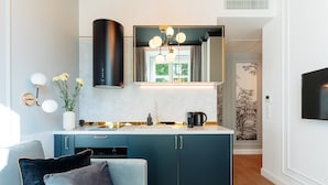 A modern kitchen with a central island, a built-in stove, and a large window. - Warsaw Story by StayLab (Warsaw)
