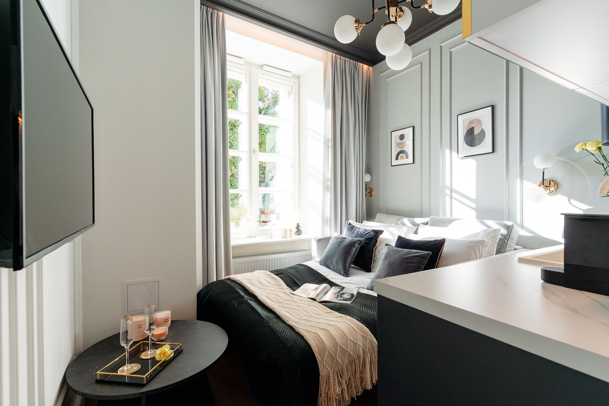 Una habitación de hotel moderna con cama, escritorio y ventana con cortinas.