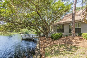 Una casa junto al lago, con muelle y mesa de picnic.