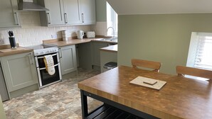 Eine Küche mit einem Holztisch, einem Herd und einem Spülbecken.